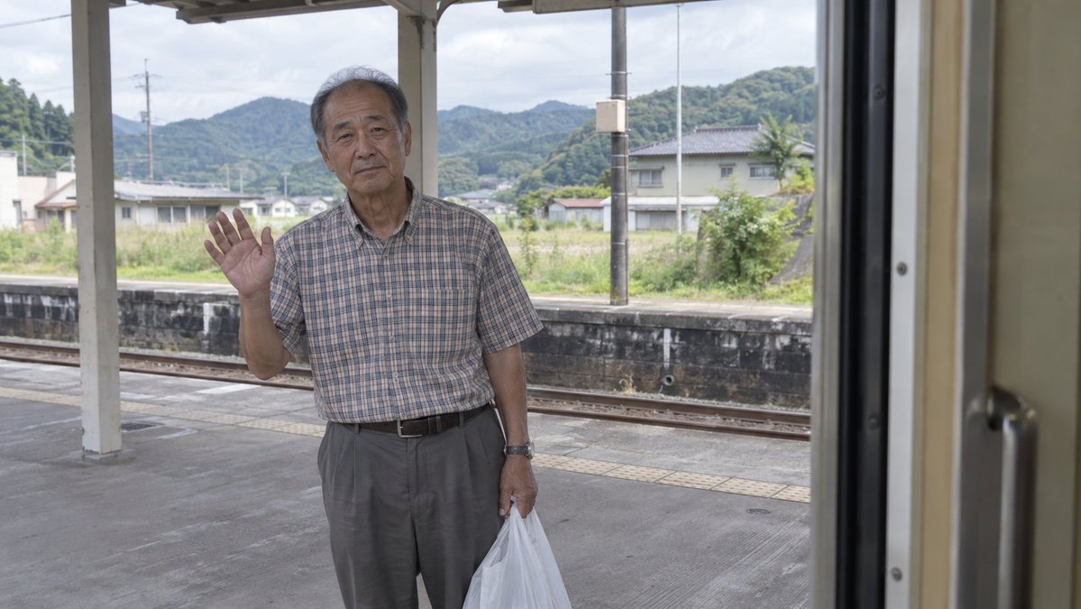 Elderly Man Waving at Rural Station (1/3)